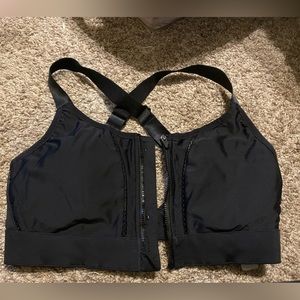Fabletics black sports bra with fish netting in the front , cross back.